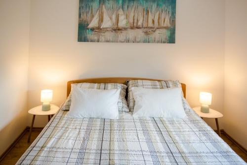 a bedroom with a bed with two lamps on two tables at Villa Ruška in Ljubuški