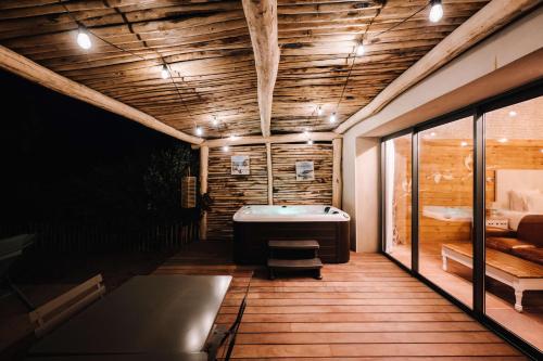 a room with a bath tub on a wooden deck at Le Hameau Des Pesquiers Ecolodge & Spa, Curio Collection By Hilton in Hyères