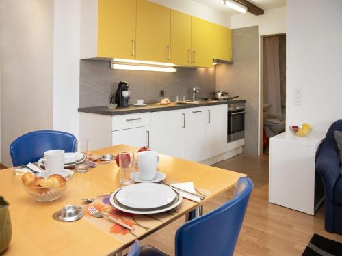 ファレラにあるApartment La Siala Apt-47 by Interhomeのキッチン(木製テーブル、青い椅子付)