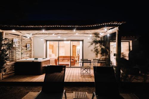 a house with a deck with a couch and lights at Le Hameau Des Pesquiers Ecolodge & Spa, Curio Collection By Hilton in Hyères