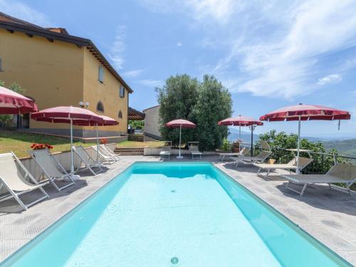 a swimming pool with chairs and umbrellas at Apartment Antico Loggiato-2 by Interhome in Pontassieve