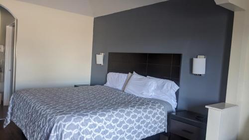 a bedroom with a bed with a black and white comforter at Rodeway Inn & Suites in Humble