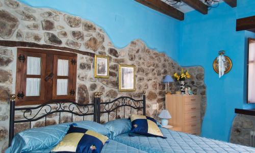 una camera da letto con un letto e un muro di pietra di La Ermita a Loroñe