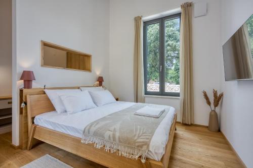 sypialnia z łóżkiem i dużym oknem w obiekcie Case Atrio w Rovinj