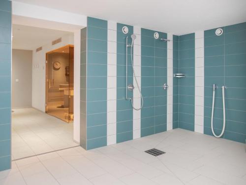 a bathroom with a shower with blue tiles at Apartment La Siala Apt-7 by Interhome in Falera