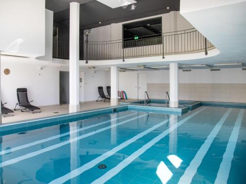 a swimming pool with blue water in a building at Apartment La Siala Apt-30 by Interhome in Falera