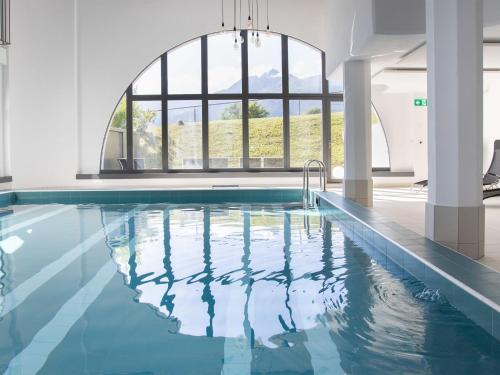 a swimming pool with a large window in a building at Apartment La Siala Apt-28 by Interhome in Falera