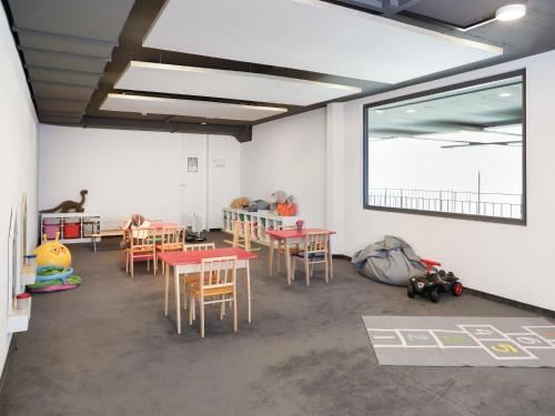a classroom with tables and chairs and a window at Apartment La Siala Apt-37 by Interhome in Falera