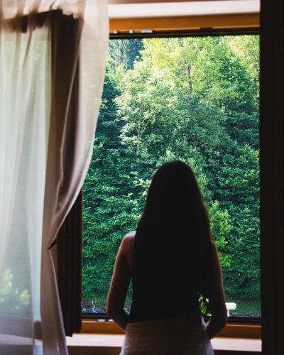 a woman sitting in front of a window at Naturae Lodge Wellness & Spa in Alleghe