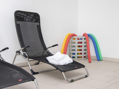 a black chair sitting in a room with a rack ofools at Apartment La Siala Apt-37 by Interhome in Falera