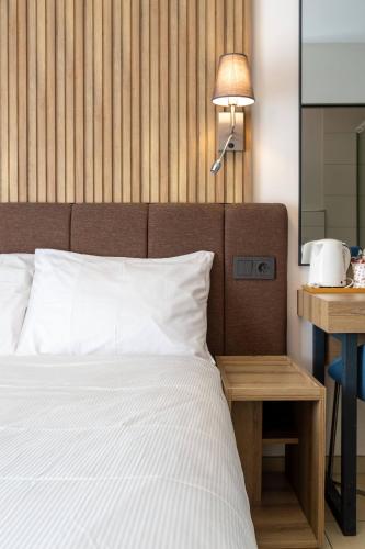 a bedroom with a bed and a table with a lamp at Nani City Hotel in Zürich