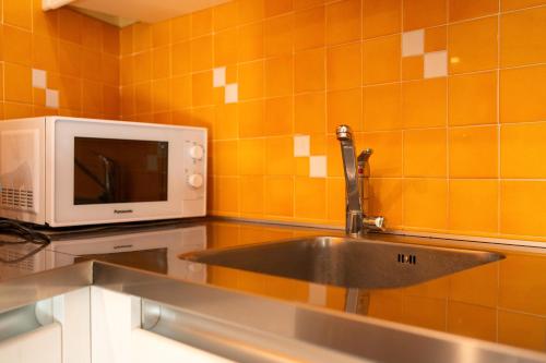 a kitchen with a sink and a microwave at Small Rustic Apartment in Scrofiano