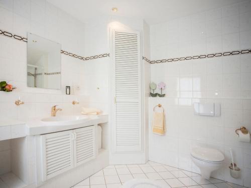a white bathroom with a sink and a toilet at Pension Haus Brieden in Winterberg