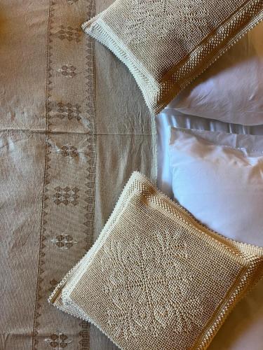 a close up of some pillows on a bed at Casa Ziranu Sa Domo e su Cantaru in Orani