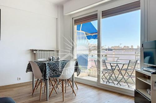 une salle à manger avec une table et un balcon dans l'établissement L'AIGLON Appartement AirCo in the town center for 4 By Sunset, à Antibes