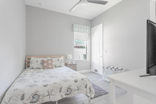 a white bedroom with a bed and a window at Seaside Serenity -Private Pool with Beach Access in Melbourne Shores