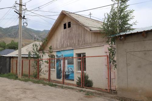 a building with a fence in front of it at Naryn Guest House in Naryn