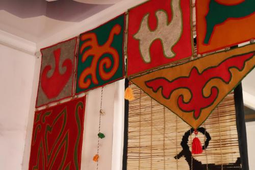 a room with paintings on the wall and a window at Naryn Guest House in Naryn