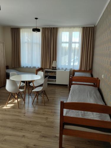 a bedroom with two beds and a table and chairs at Agroturystyka Goliat in Zapolice