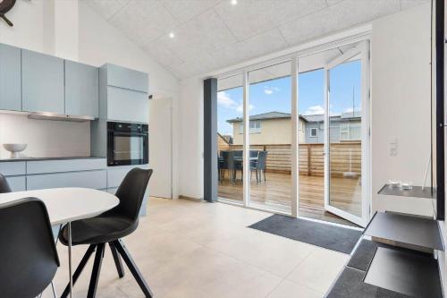a kitchen with a table and chairs and a large window at 782-Hvide-Sande-Norregade-2-nr-25 in Hvide Sande