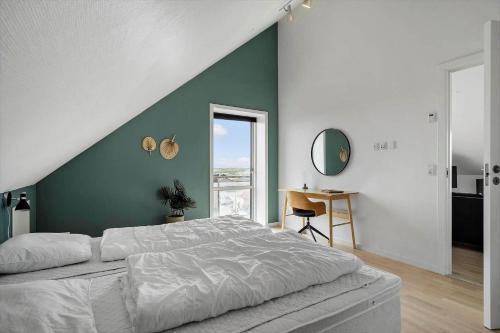 una camera con un letto bianco e una parete verde di 799-Hvide-Sande-Strandgade-6-Lejl-6 a Hvide Sande
