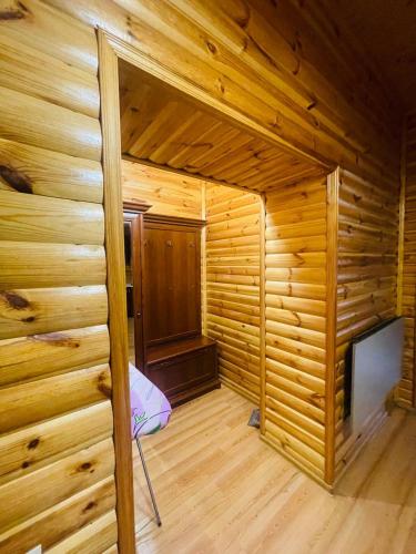 an empty wooden room with a bed in a wooden house at Ethno Complex Ukrayinske Selo in Buzovaya
