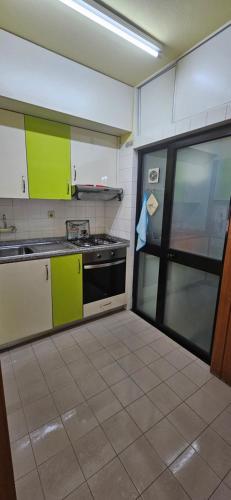 a kitchen with green and white cabinets and a stove at Mimos House's Rio e Serra in São Pedro do Sul