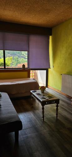a room with a bed and a table in it at Mimos House's Rio e Serra in São Pedro do Sul