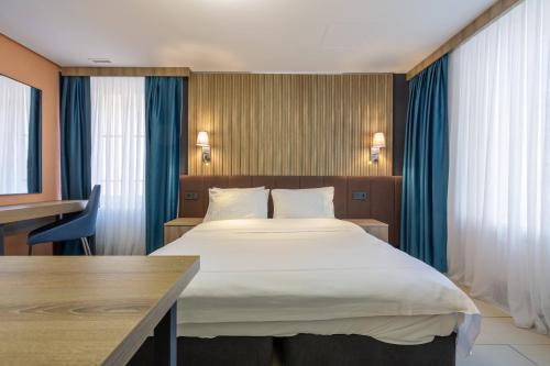 a hotel room with a large bed and a desk at Nani City Hotel in Zürich