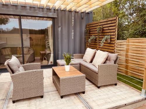a patio with wicker chairs and a table at Le Temps d'une Nuit 