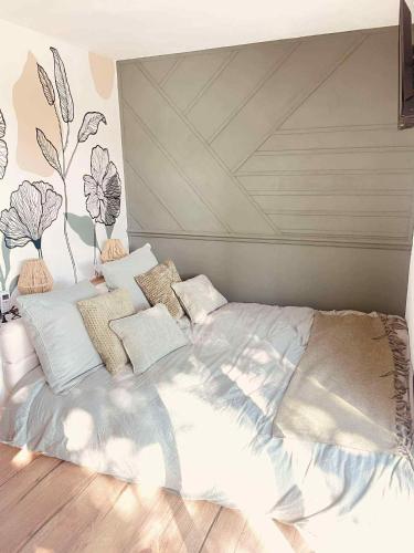 a bedroom with a large bed with white sheets and pillows at Le Temps d'une Nuit 