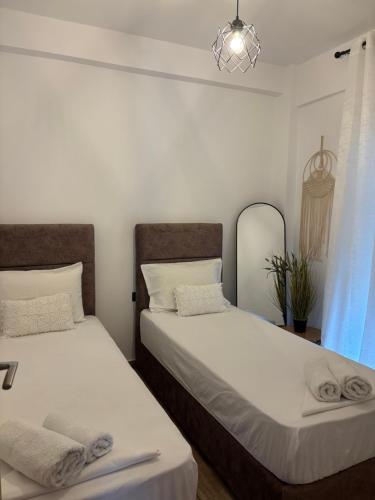 two beds sitting next to each other in a bedroom at Pinelopi family Apartment in Hanioti