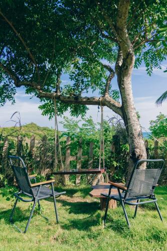 two chairs and a swing under a tree at Peaceful Hill Homestay in Ke Ga