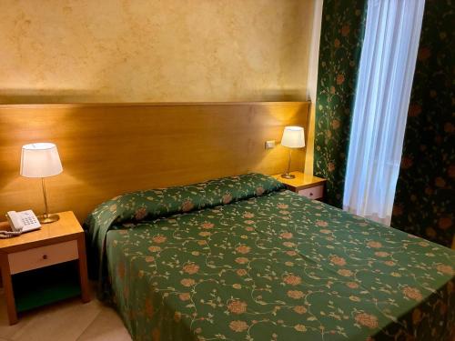a hotel room with a bed and two tables with lamps at Park Hotel Villa Americana in Rodi Garganico