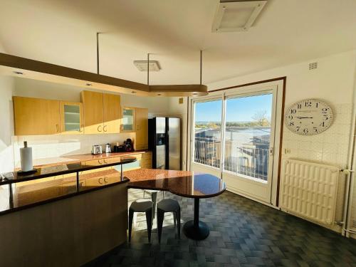 une cuisine avec une table et une horloge au mur dans l'établissement Lappart Léonard 10 Couchages, à Reims