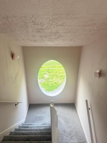 a round window in a room with stairs at Poconos Modern Chalet-Hot Tub-Home Theater-Lake in East Stroudsburg