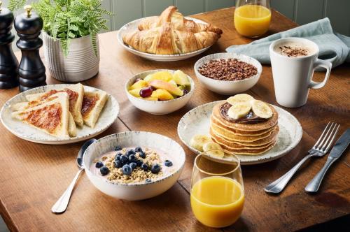 a wooden table topped with plates of breakfast foods at Premier Inn Cork City Centre in Cork
