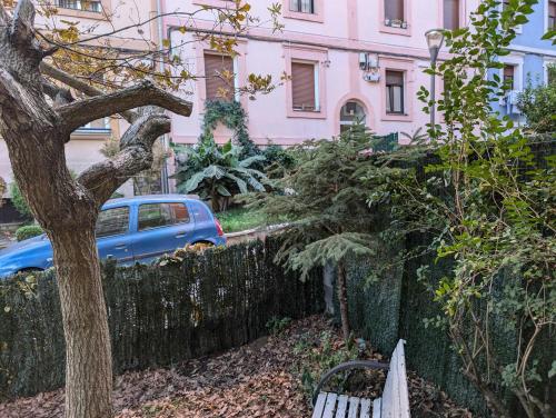 a bench in front of a fence and a pink building at Jardin secreto by Oasis Blibao ebi02374 in Bilbao