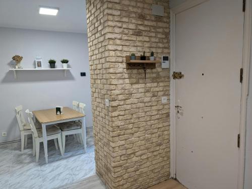 a room with a table and a brick wall at Jardin secreto by Oasis Blibao ebi02374 in Bilbao