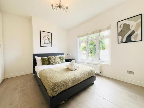 a bedroom with a bed with a teddy bear on it at Bright 2-bed Flat - 1 Min To Enfield Lock Station! in Enfield Lock