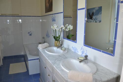 a bathroom with two sinks and a shower and a tub at Château de la Saulinière in Kain