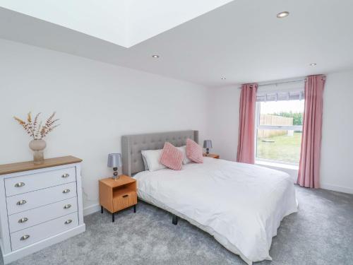 una camera da letto con un letto, un comò e una finestra di Meadow View a Beverley