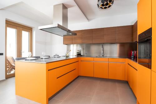 an orange kitchen with wooden cabinets and a sink at Dvor Aaki in Novi Vinodolski