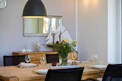 a dining room table with a vase of flowers and a mirror at Salzwiesenhaus in Kosel