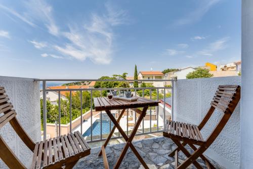 two chairs and a table on a balcony with a view at Dvor Aaki in Novi Vinodolski