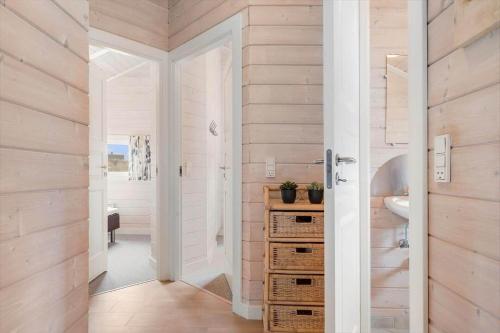 a bathroom with wooden walls and a sink and a mirror at 555-Hvide-Sande-Tornbjerrevej-32 in Havrvig