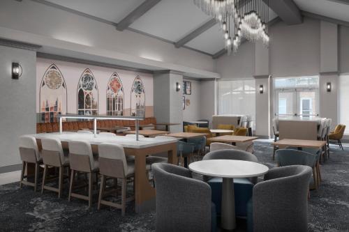 a dining room with tables and chairs and a chandelier at Homewood Suites by Hilton Princeton in Princeton