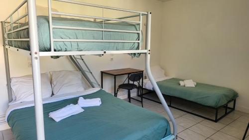 a bedroom with two bunk beds and a table at Auberge de La Vielle Halle in Souppes-sur-Loing
