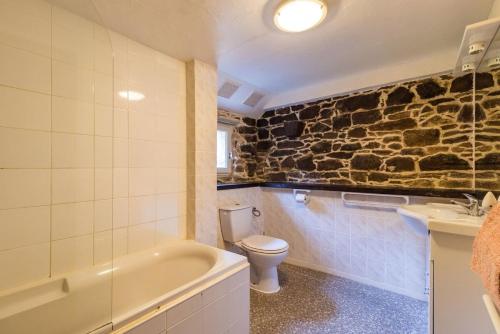 une salle de bain avec une baignoire, des toilettes et un lavabo dans l'établissement Moulin de la Touche - Mill Piscine Nature, à Plouguenast Langast