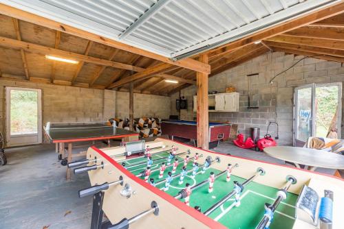 a room with a ping pong table and a pool table at Moulin de la Touche - Manoir Piscine Nature in Plouguenast Langast